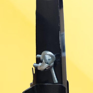 Close-up of a black metal mounting bracket secured with a silver bolt and washer against a solid yellow background.